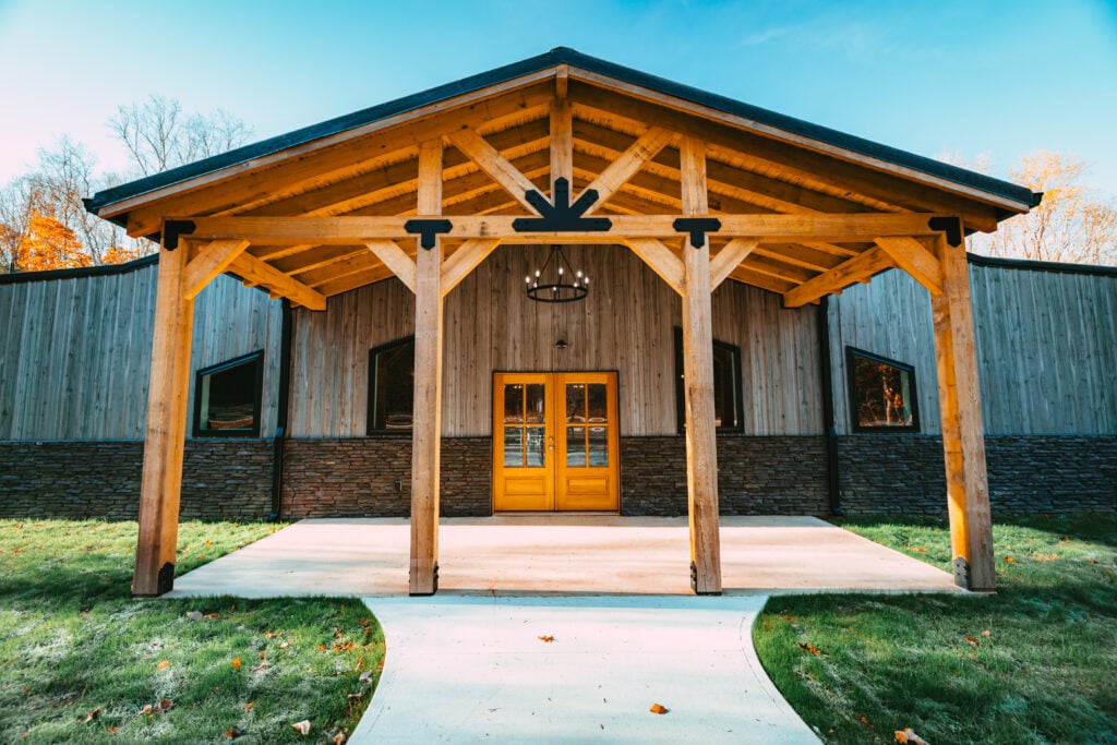 Exterior of The Willows event space at The Bridges in Wayne County with timber beams, wooden doors, and a covered entrance.